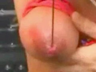 girl getting her nipple skewered